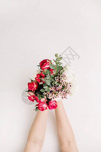 女人手握着玫瑰花的束叶树枝野花图片