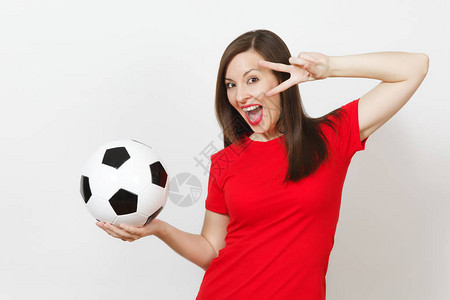 漂亮的欧洲年轻女子足球迷或穿着红色制服的球员拿着经典足球图片