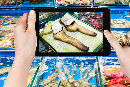 旅游概念游客在平板电脑上拍摄春季广州市黄沙水产品交易市图片