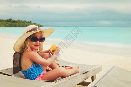 晒娃保护阳光在热带海滩晒背景