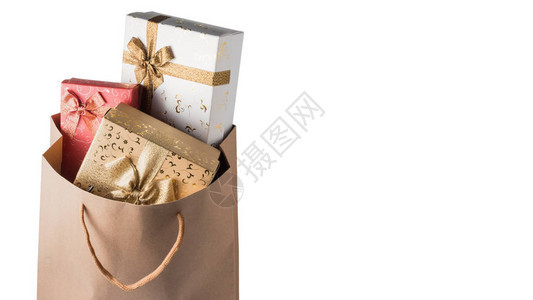 白色背景的棕色纸袋中的礼品盒图片