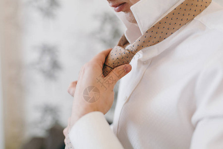 年轻的剃须新郎穿着白色的婚纱衬衫图片