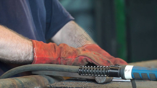 手工铁匠在车间用锤子锻造热铁图片