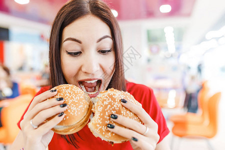 学校食堂快乐女孩吃两个汉堡包一个吃一背景