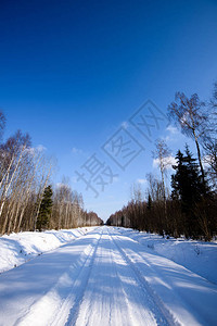 深雪中覆盖的冬季雪路车胎轨迹向背景图片