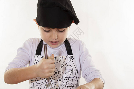 可爱的小衣服厨师男孩准备纸杯蛋糕图片