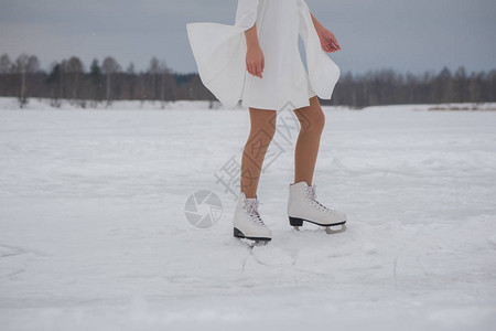 冬天穿白衣服和溜冰在户外雪地上露天滑图片