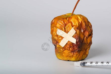 灰色表面上的干苹果和胰岛素超薄注射器特写图片