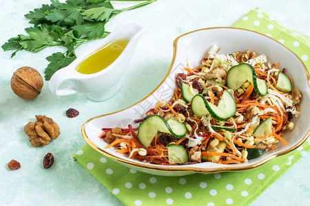 与发芽的豆绿胡萝卜甜菜黄瓜卷心莴苣在浅绿色背景的素食沙拉用醋汁调味饮食和健康食品的概图片