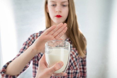 乳糖不耐症乳制品不耐症的年轻女孩拒绝喝牛奶浅景深选择地图片