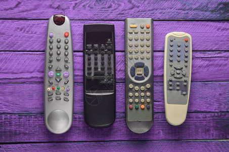 许多过时的电视遥控器放在紫罗兰生图片