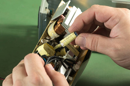 技术人员维修电路板和更换电容器图片