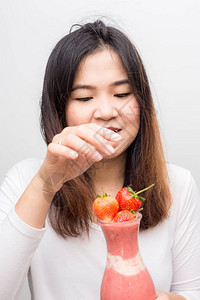 有趣的亚洲女人喝草莓冰淇图片