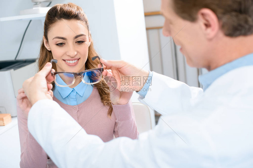 眼科医生在诊所给病人戴微笑眼镜的眼科医图片