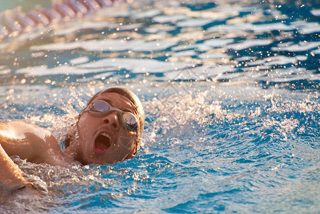 在游泳池锻炼游泳男子在蓝色泳池图片