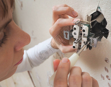 女电工修理墙上的插座图片