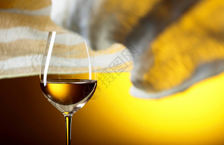 黄色背景的白葡萄酒杯子黄色织物在风中飘背景图片