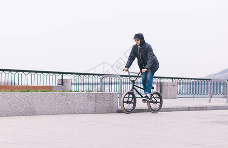 时髦的BMX骑自行车者沿水边行驶图片