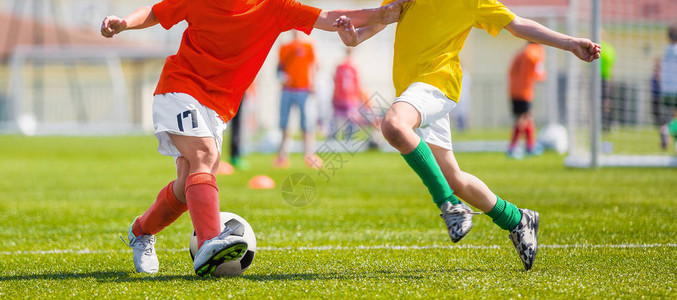 一群小男孩在运动场上踢足球比赛足球学校比赛黄色和红色球衣衬衫的儿图片
