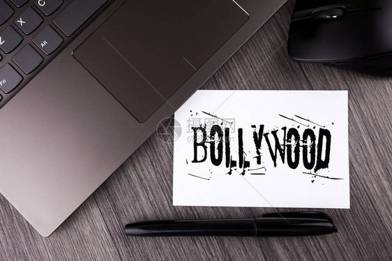 Bollywood商业图片展示印度电影院的娱乐来源笔记本纸木制背景笔鼠PaptopMous图片
