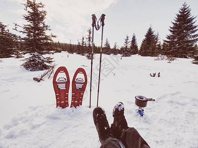 冬季步道期间的午餐时间在雪地露营和烹饪红色的雪鞋和登山杖站在雪地图片