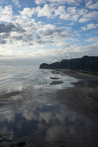 白天的海岸线和海上岩石景观图片