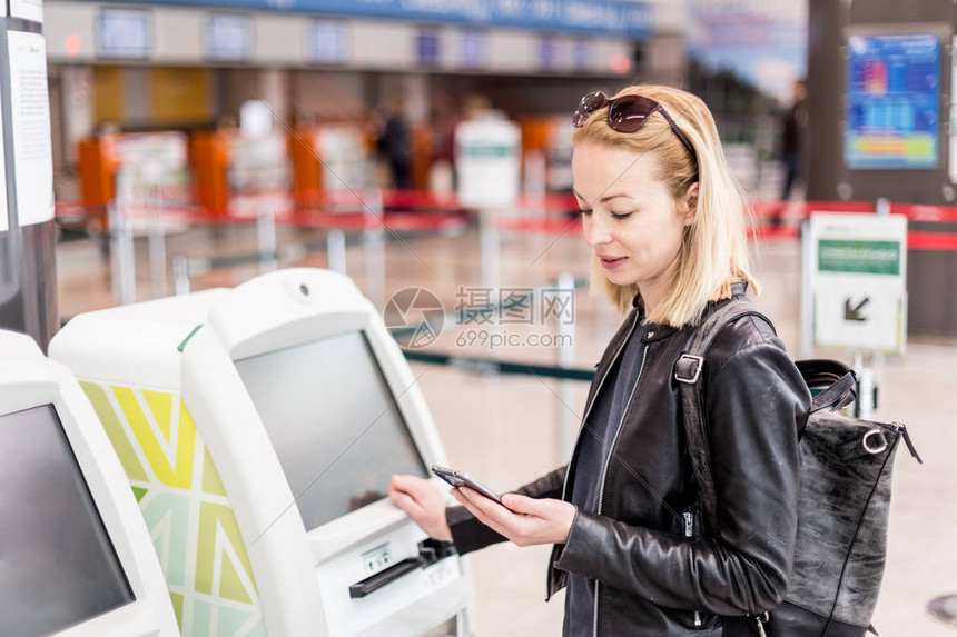 在机场使用智能手机应用程序和值机获取登机牌的休闲白人女在机图片