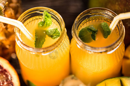 含有各种冷压原始热带果汁或冰冻果汁的罐子菠萝芒果和橙色混合剂新品和夏季饮料图片