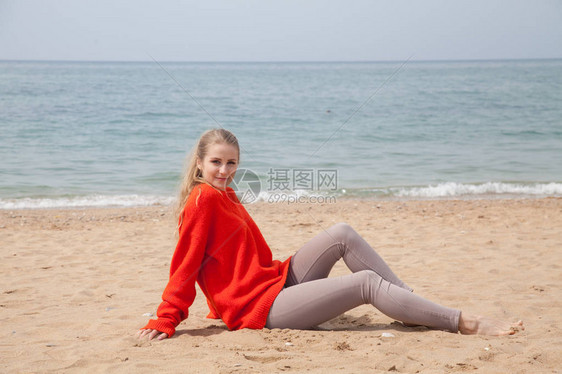 坐在沙滩海滨岸边的红图片