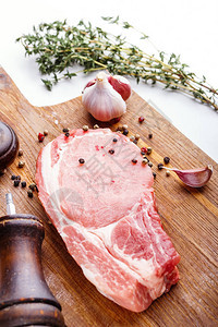 生猪肉牛排一束新鲜百里香大蒜胡椒豌豆和胡椒磨图片