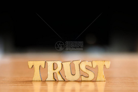 信任一词由木制字母组成木刻在桌子上图片