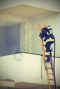 消防员与氧气瓶一起攀爬木梯子图片