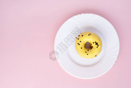 甜圈覆盖着黄色玻璃粉红色背景的白板上喷图片