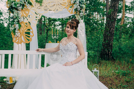 穿着婚纱的漂亮女人在光带上装饰着鲜花图片
