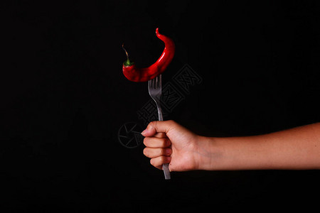 黑背景的红辣椒叉切成红热辣椒女人图片