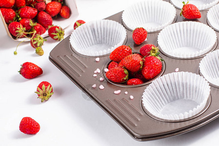 烘烤准备野草莓和纸杯蛋糕盘背景图片