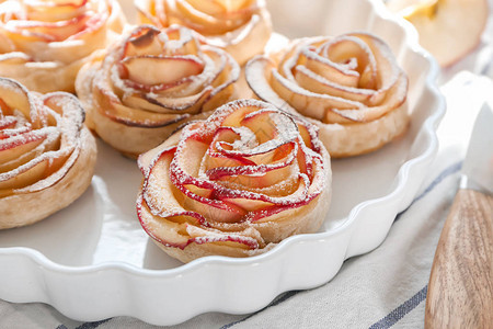 桌上有美味的玫瑰形苹果糕点的菜图片