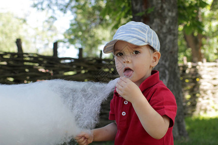 有趣的小男孩在公园吃棉花糖图片