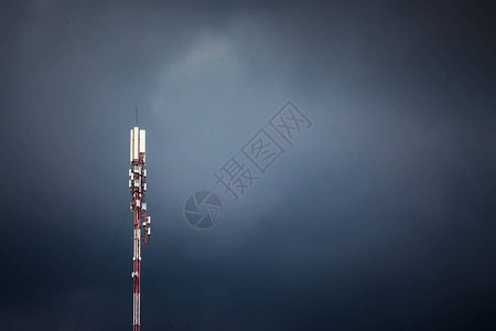 在黑暗的风雨如磐的天空背景上的蜂窝天线在恶劣的天气条件下接收信图片