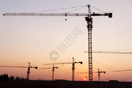 建筑工地夕阳下的工业起重机背景图片