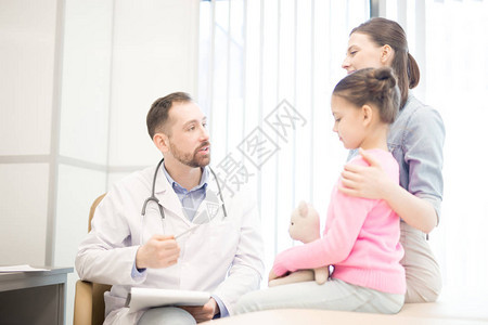 年轻医生在诊所为小病人提供配有处方图片