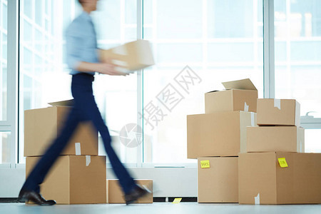 商人在搬迁期间将箱从一个办公室运到另一个办公室背景图片