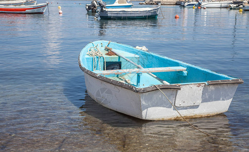 水晶般清澈的水面上的典型船非机动海上车辆停靠在海边的浅水区捕鱼机图片