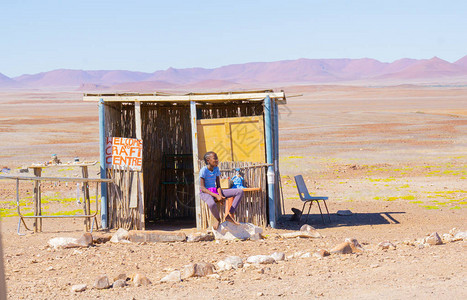 在纳米比亚农村的非洲年轻妇女坐在摊位上图片