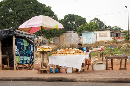 非洲科特迪瓦妇女及其女儿在街头市场卖面包图片