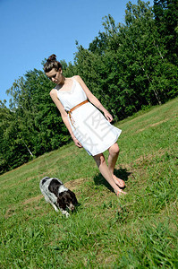 穿着白裙子的女人和她最爱的狗在一起乡村的女模特图片