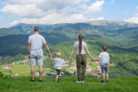 家庭节日父母和两个儿子仰慕河谷远处的山图片