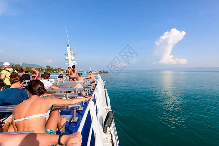 一群游客在夏季乘船在海上旅行期间在甲板上休息图片