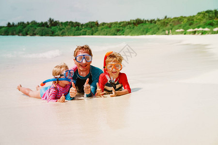 快乐的父亲儿子和女儿在海滩上潜图片