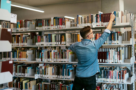 人在书店找书图书馆的学生试图在书架上找到教科背景图片